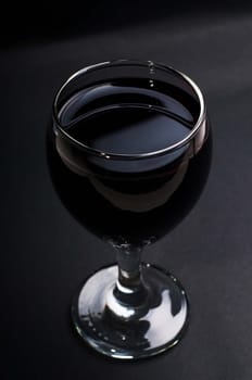 Shot of glass red wine on black background