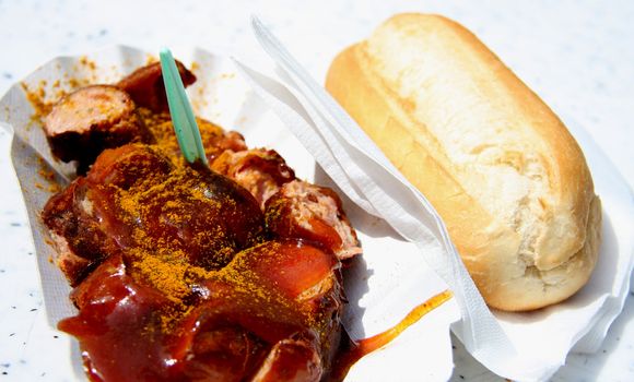 Curry wurst with bread on white.