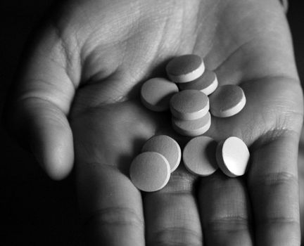 Hand holding a lot of pills. Black and white image.