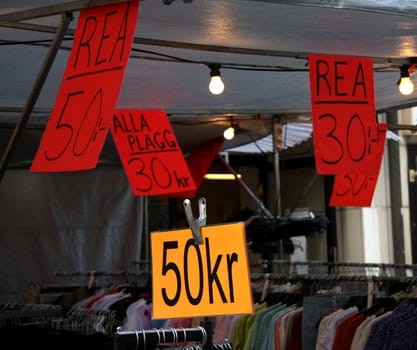 Sale sign with prices in outdoor market.