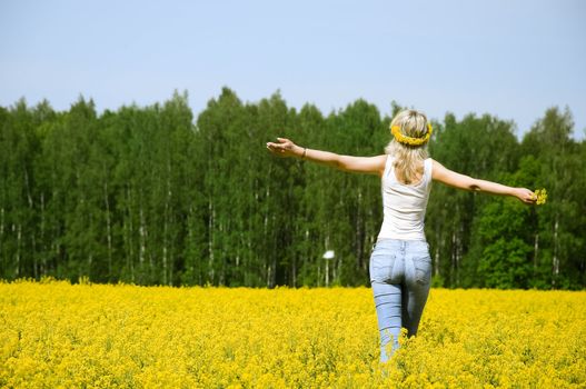 happy young woman is standing on a flower field