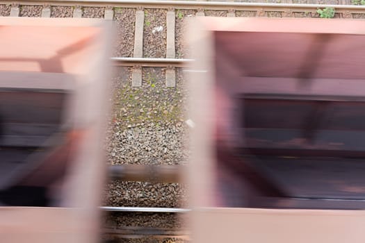 Fast moving freight cars (motion blur) of cargo train.