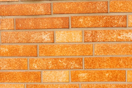 Background texture pattern of exterior wall with fake ocher brick siding.