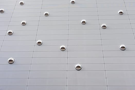 Mirror spheres in modern buiding facade reflect downtown street.