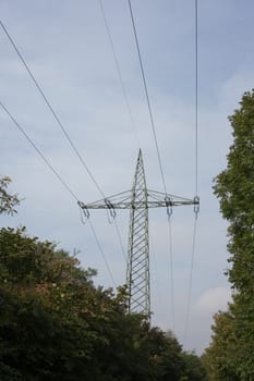 Steel pylon of high voltage electric power transmission line in green rural setting.