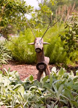 Rustic horse or deer made from tree branches in flower garden
