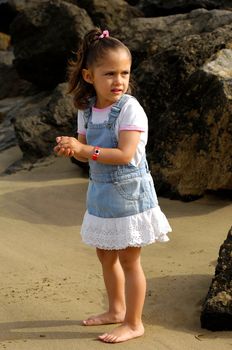 Sweet child alone on beach.