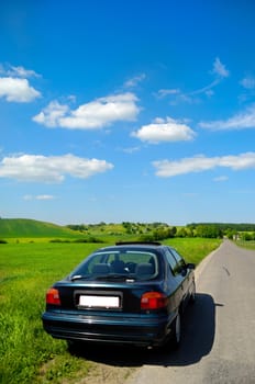 Car is parked in road side with a beautiful landscape.