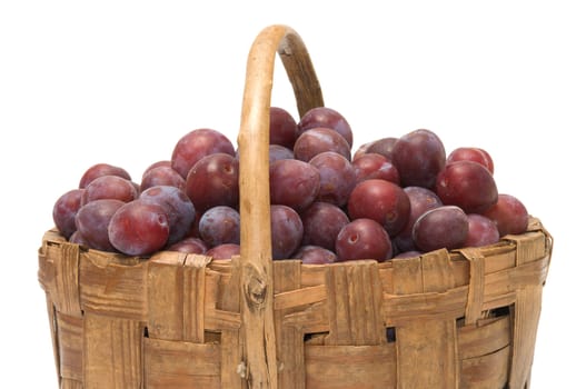 Wattled basket with ripe plums it is isolated on a white background.