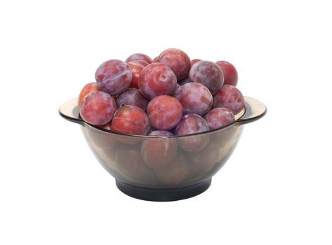 Ripe plums on a plate isolated on a white background.