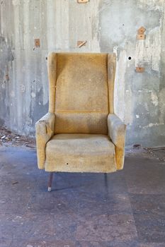 A retro winged back chair in bad condition