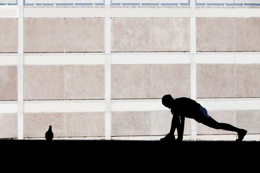 Single woman stretches before she goes for run.