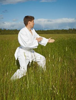 The young man goes in for karate in the open air