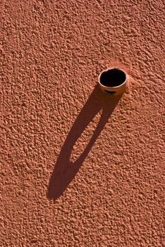 Shadow of a pipe protruding from the wall.
