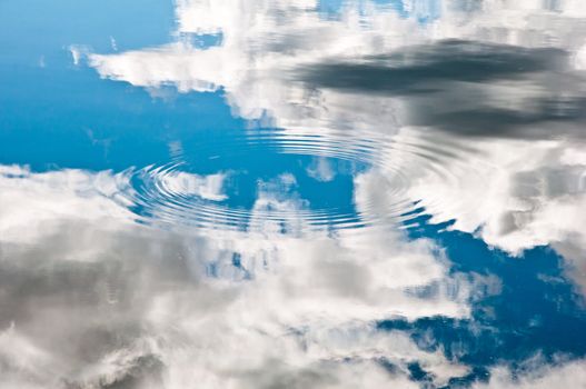 Reflection of the bright blue sky in the calm water of a lake