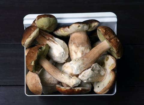 Various wild mushrooms in bowl on the wooden table