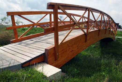Wooden bridge over the small grassy ditch