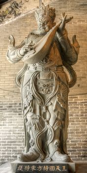 Stone statue of Chinese god, below words was his name in Chinese.