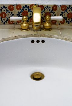 Detail of luxury sink with gold tap in hotel room