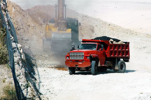 Red van and yellow excavator on building ground in Mexico city