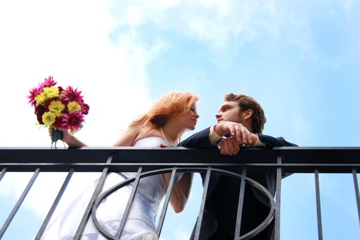 A bride and groom on a balcony