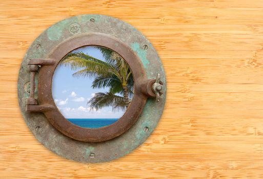 Antique Porthole with Tropical Beach View on a Bamboo Wall Background.