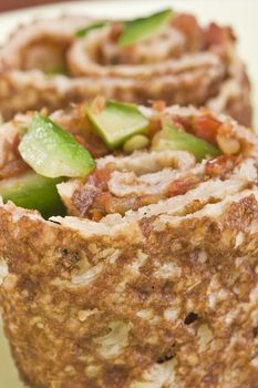 Close-up of a rolled pancake with salsa inside.