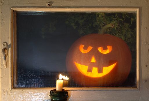 Glowing pumpkin head behind a night window looking at your room