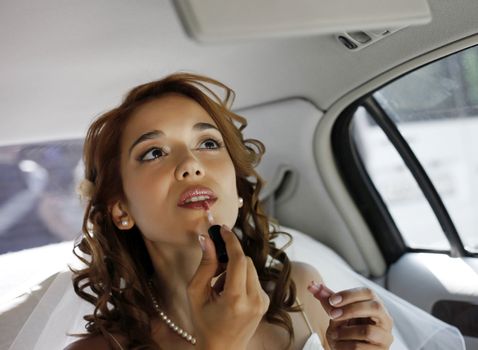 The beautiful bride in the automobile. 