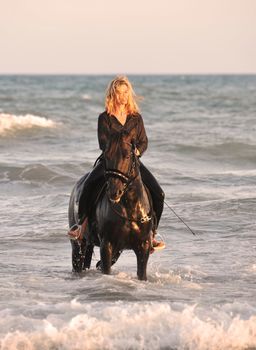 blond woman on her stallion in the sea