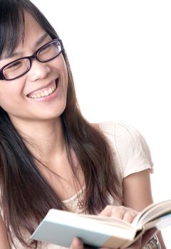 A young asian woman reading a book and laughing out loud wearing glasses