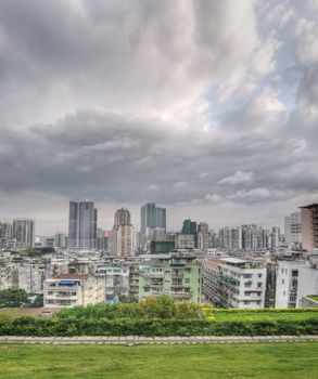 City skyline in Macao with buildings and skyscrapers under clouds in sky in Macau, China.