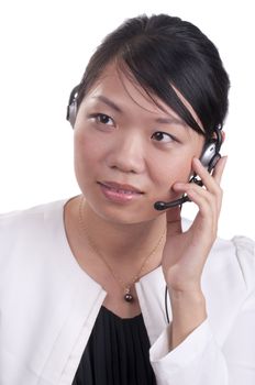 Young asian receptionist talking on hands free headset to customer isolated
