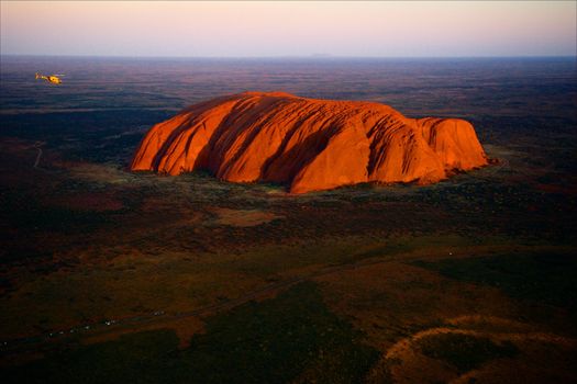 Uluru./ Orange Uluru in bright beams of the sunset sun. Aerial photography.