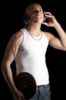 A good looking, muscular built, man on a black background with earphones.