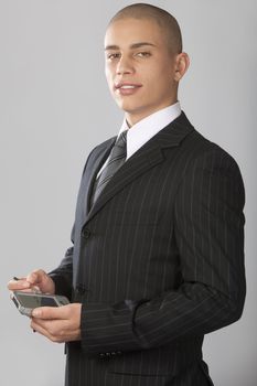 A young good looking businessman on a gray background.