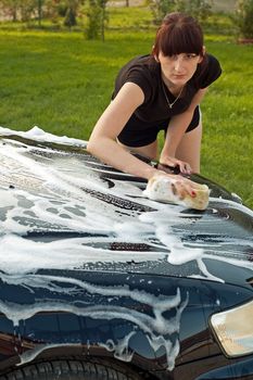 Adult cleaning her car outside