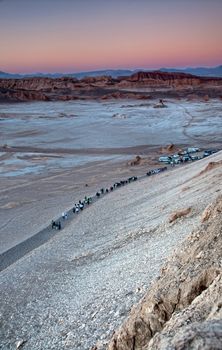 Tourists returning to their transportation after watching the sun setting at Moon Valley in the desert of Atacama, Chile 
