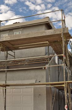 New Home Construction Scaffolding with Blue Sky and Clouds in Background