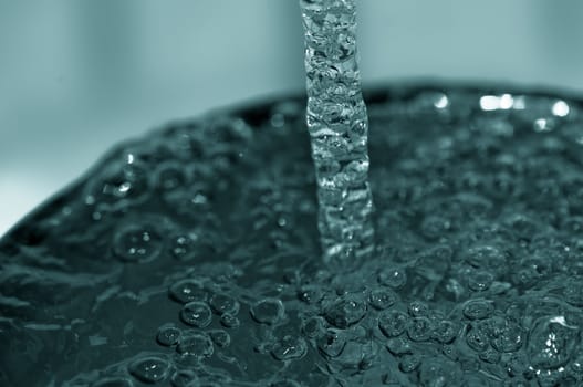 Close Up of Blue Water Pouring into a Glass