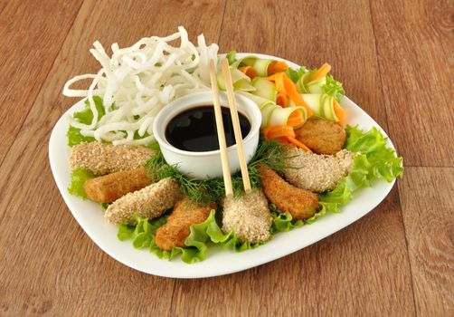 Chicken fillet in breadcrumbs and sesame with fried rice noodles with vegetables