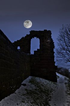 A very spooky castle in the moonlight after it has snowed

