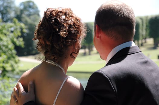 Wedding couple standing together in a park.