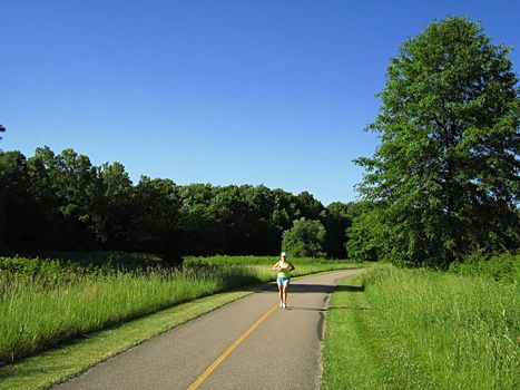 A photograph of a person running along a trail.