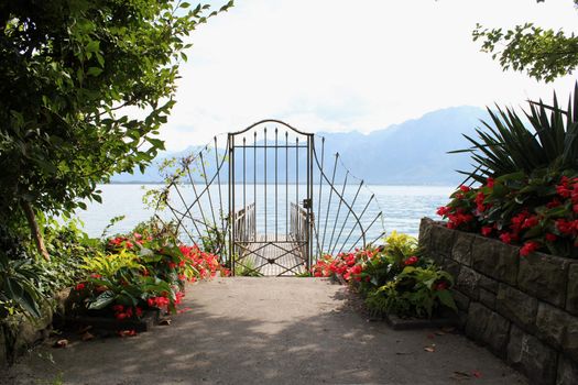 Red flowers and gate to heaven throug water and mountain