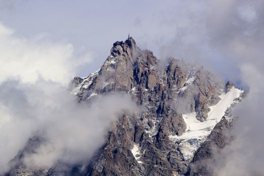 View of Aiguille Du Midi surrounded by lots of clouds from Chamonix, France