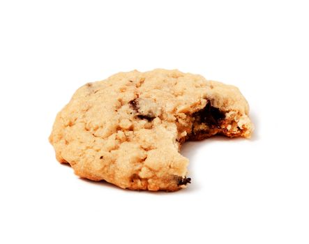 An isolated chocolate chip cookie with a bite out of it