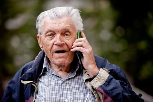 A senior talking on a cell phone outdoors
