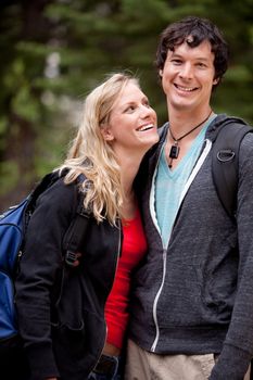 A man and woman outdoors on a hike in a forest