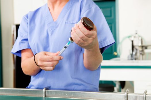 A medical professional filling up a needle with medicine